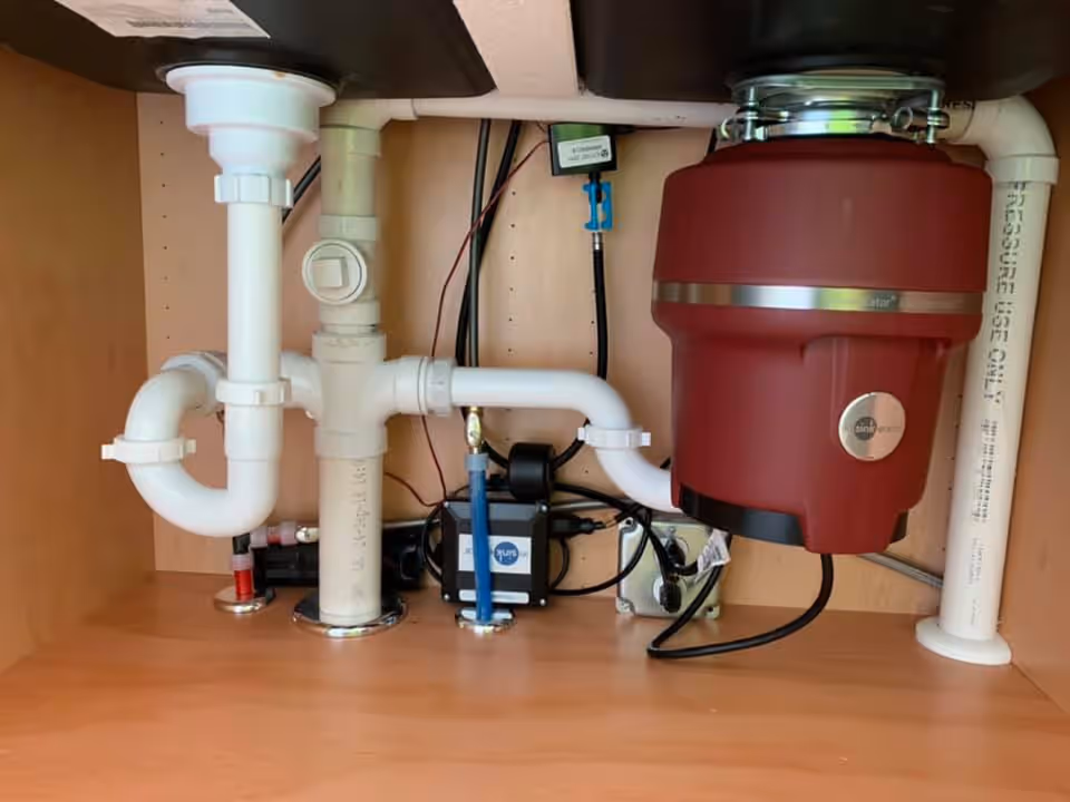 Under-sink drain plumbing with a garbage disposal unit